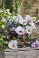 Forget-me-nots (Myosotis), weeping cherry and violets in vases