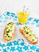 Toast with ham, cheese and cucumber with glass of orange juice