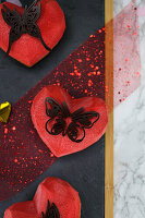 Heart-shaped currant tartlets decorated with chocolate butterfly