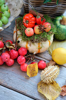 Autumn decoration with pumpkin, ornamental apples, and autumn leaves