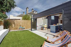 Terrace with lawn, view into open kitchen