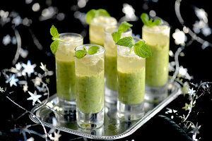 Festliche grüne Erbsensuppe serviert in Gläsern
