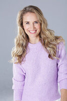 Blonde woman wearing a purple sweater