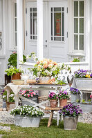 Blumenarrangement vor weiß gestrichenem, skandinavischem Haus