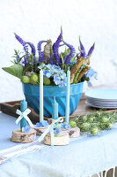 Vintage Gugelhupfform with Veronica, hydrangeas, and birch branches, in front of it candles on birch branches