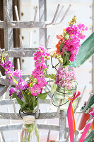 Hanging bouquets of snapdragons, butterfly bushes and levkojen on old industrial frame