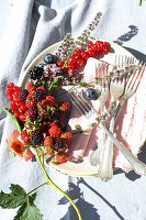 Berry branches and herb blossoms as plate decoration