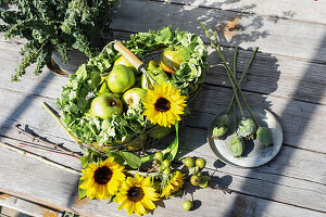 Bouquet of sunflowers and poppy capsules in milk cans