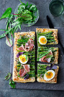 Asparagus puff pastry pie with egg and bacon