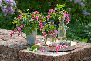 Bouquet of Tearful Heart (Dicentra Spectabilis) and strawberry flowers in vases