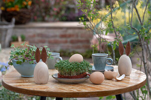 Easter decoration, eggs, made bunny figures, sprouts on patio table