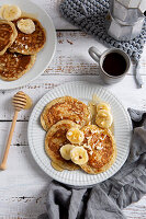 Vegane Bananen-Pancakes mit Bananenscheiben und Honig