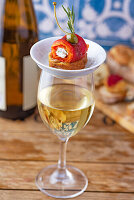 A glass of white wine and Pincho made of roasted peppers and sheep's milk cream cheese