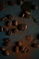 Coffee beans with ground coffee on a dark base