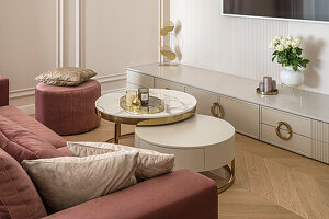 Living room, salon, round coffee tables and a couch, beige pastel colours and brass/golden details, tv corner