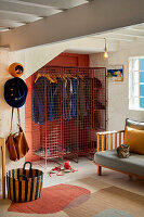 Metal wardrobe in corner of living room with cat on sofa and patterned rug