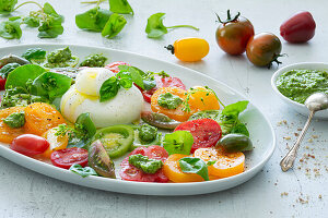 Caprese salad with colorful tomatoes, burrata and purslane pesto