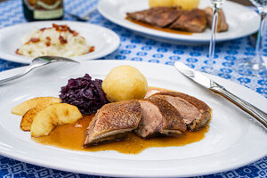 Roast goose with potato dumplings, red cabbage and apple wedges