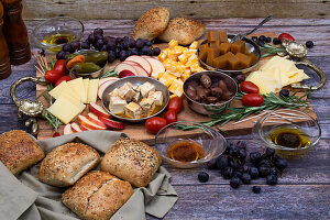 Cheese board with fruit, olives, grapes, and bread