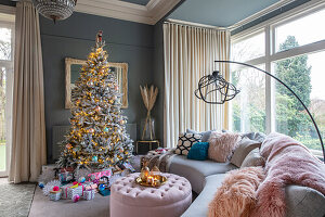 Wohnzimmer mit geschmücktem Baum und Weihnachtsgeschenken