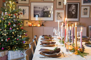 Festlich gedeckter Esstisch mit Weihnachtsbaum und Kerzenlicht