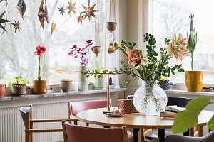 Bright dining area with flower arrangement and window decoration made of stars
