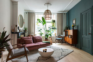 Living room with retro furniture, houseplants and rattan lamp