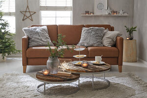 Living room with leather sofa, wooden coffee tables and Christmas decorations