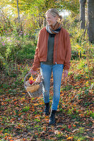 Frau mit Picknickkorb beim herbstlichen Spaziergang