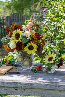 Bouquet with sunflowers (Helianthus), roses (Rosa), broccoli, wild carrot, foxtail (Amaranthus) on garden table