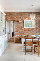 Kitchen with brick wall, rustic dining area and vintage poster