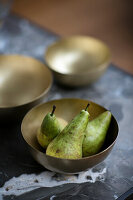 Three pears in a golden bowl