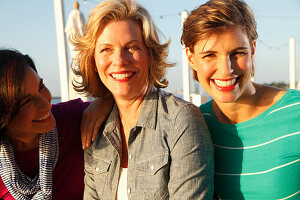 Three good-humoured girlfriends on a ship