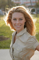 Blonde woman in light blouse dress outside