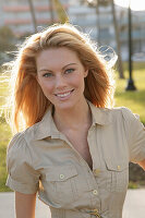 Blonde woman in light blouse dress outside