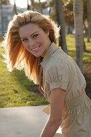 Blonde woman in light blouse dress outside