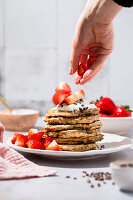 Pancakes with strawberries, cocoa nibs, and yogurt