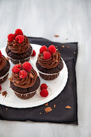 Schoko-Cupcakes mit-Schoko-Topping und Himbeeren