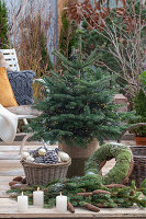Weihnachtsschmuck Nordmanntanne mit Lichterkette und Tannenzweige auf der Terrasse
