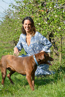 Brünette Frau mit Hund im Garten