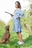 Brunette woman with dog in the garden