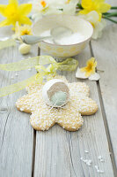 Flower-shaped Easter cookie with pearl sugar, eggshell with candy egg