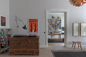 White-painted living room with antique wooden chest of drawers and view into the study