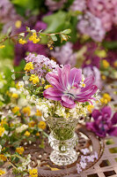 Bouquet of tulips (Tulipa), lily of the valley (Convallaria), lilac (Syringa) on patio table