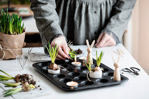 Grape hyacinths in egg shells, tea lights and wooden Easter bunny figures