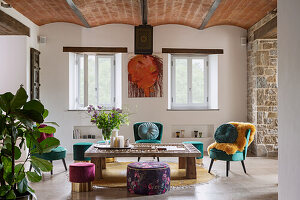 Living room with vaulted ceiling, wooden table and green velvet chairs