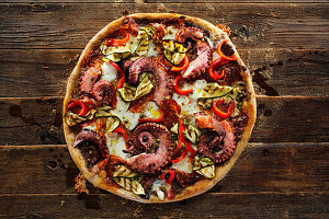 Potato dough pizza with tapenade, octopus, chorizo and zucchini