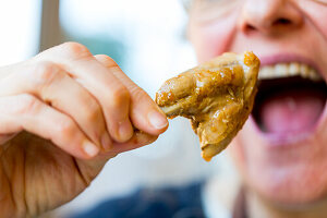 Man bites into fried chicken wing