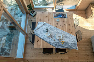 Dining room with large wooden table and black metal chairs, view from above