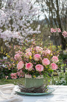 Bouquet of forsythia branches and roses, and birch branches as table decoration